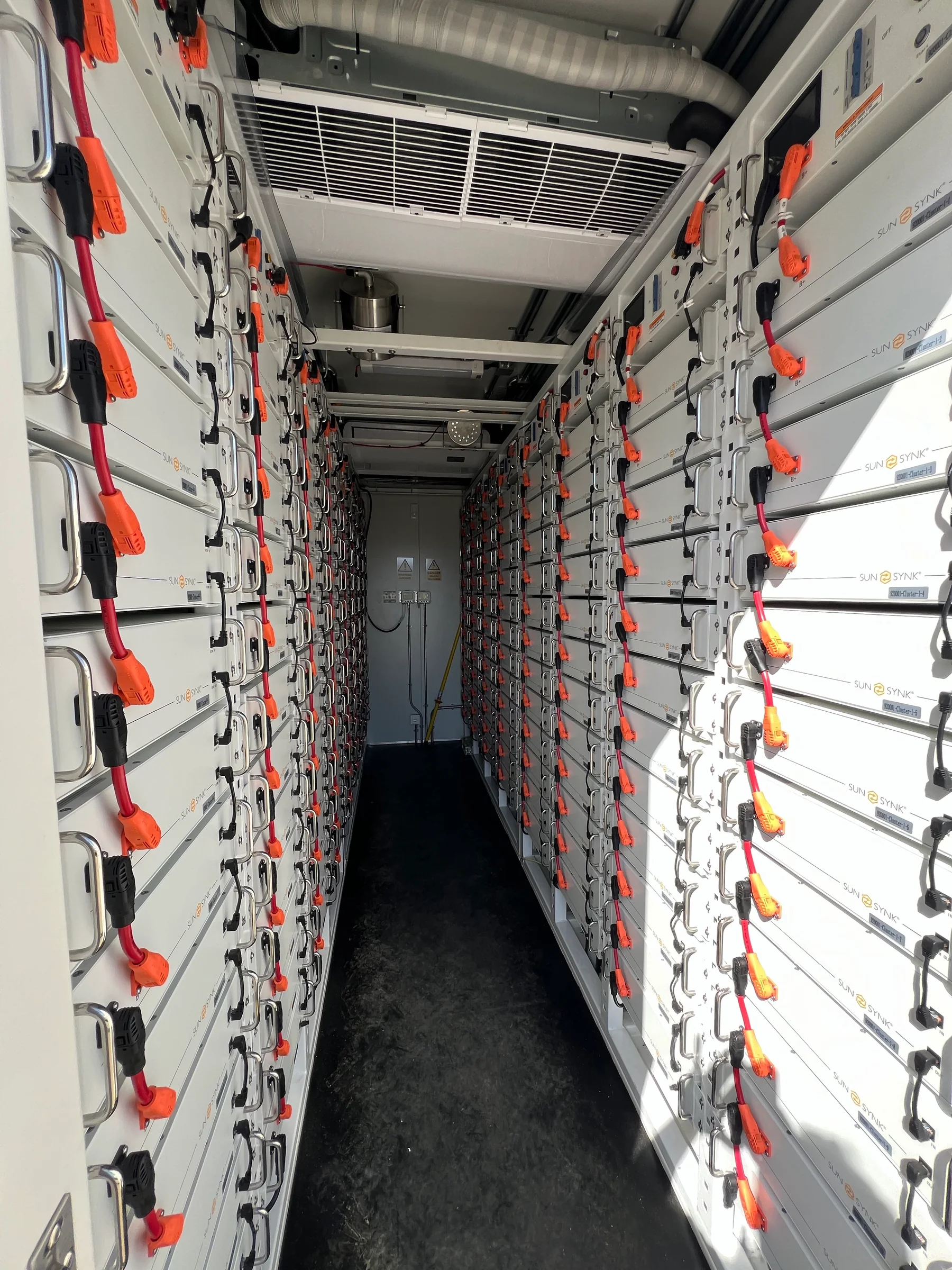 Rows of battery modules inside a BESS container